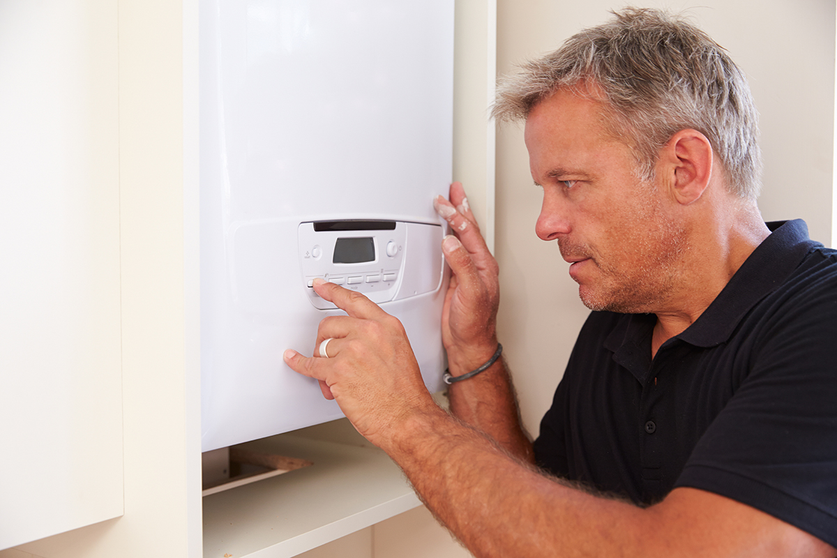 Middle aged boiler technician servicing a domestic boiler